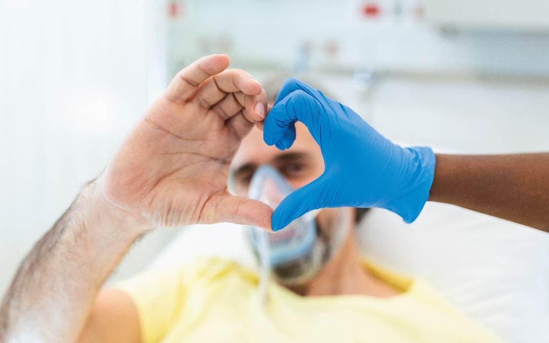Patient & clinician making heart with hands