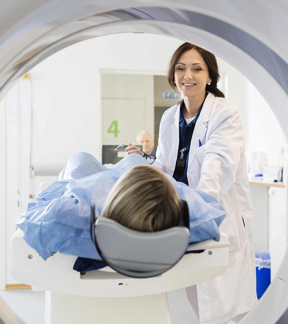 A healthcare professional preparing a patient for an MRI scan in a hospital setting.